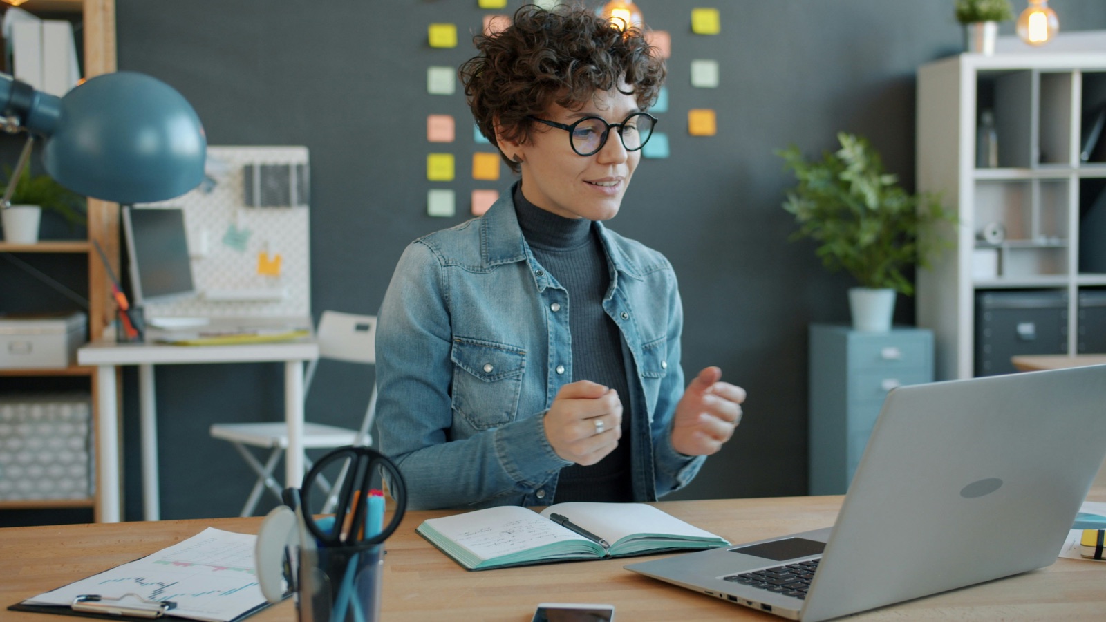 Facilitator gesturing during a video call at her laptop