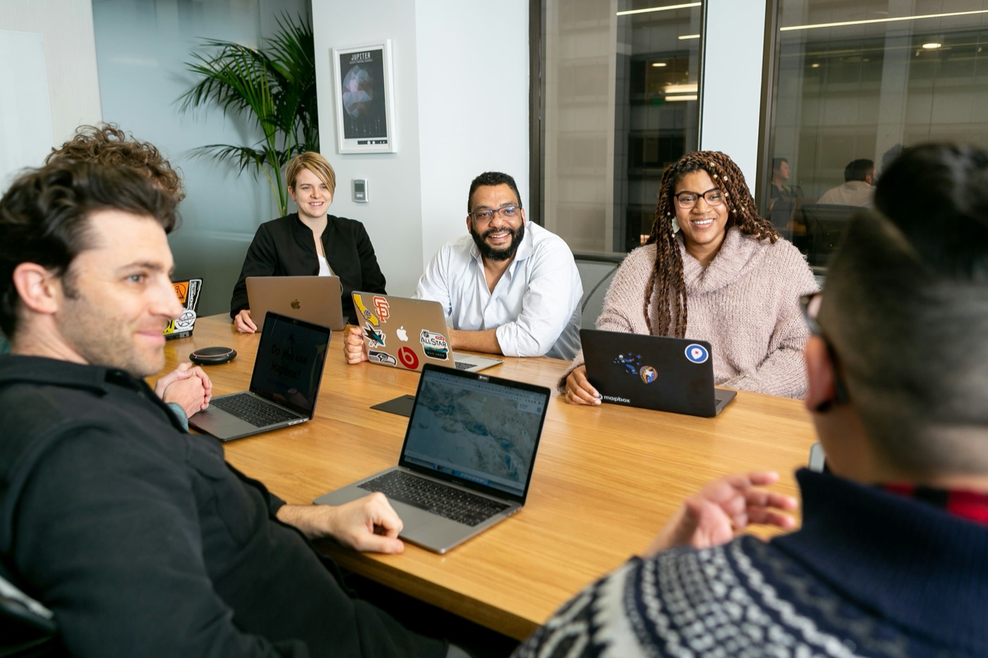 Team collaborating around a conference table with laptops